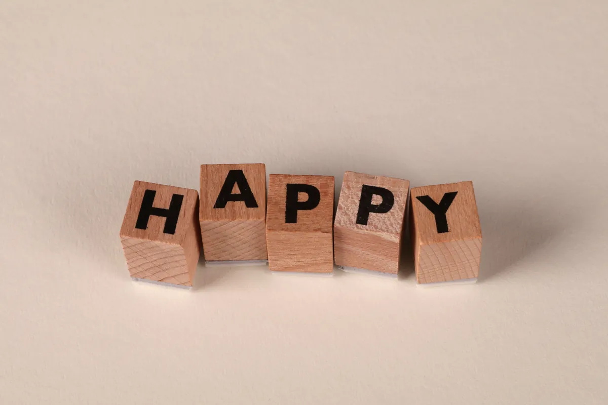 Bloques de madera formando la palabra 'happy'